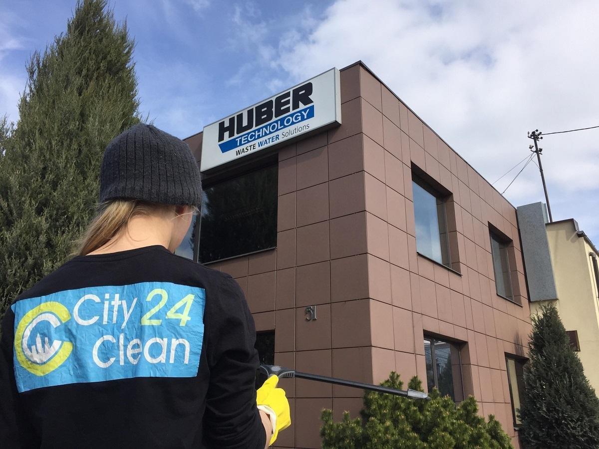 pracownik firmy CityClean24 na tle budynku firmy Huber Technology